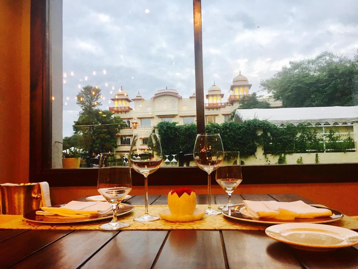 a table with wine glasses and a view of a building at Jai Mahal Palace in Jaipur