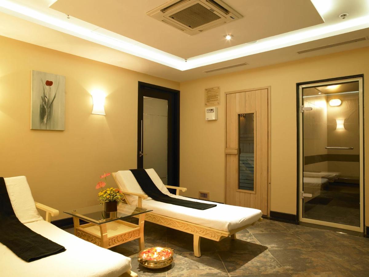 a living room with two white chairs and a table at The Zuri Whitefield Bengaluru in Bengaluru