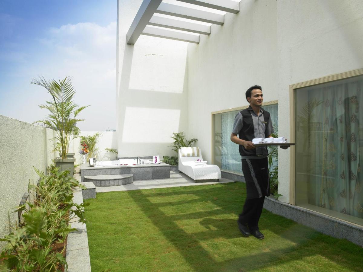 a man holding a plate of food in a house at The Zuri Whitefield Bengaluru in Bengaluru