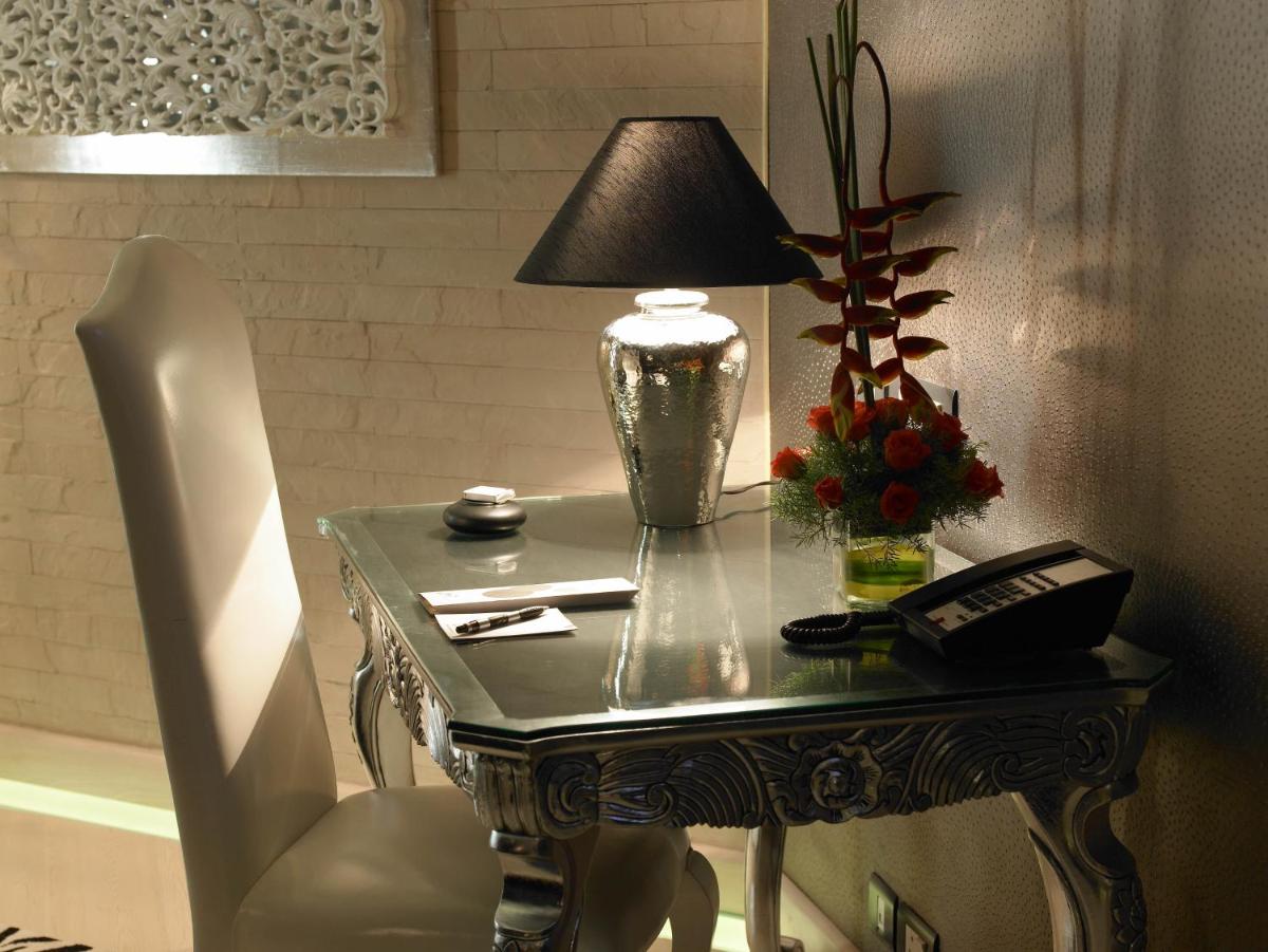 a table with a lamp and a telephone on it at The Zuri Whitefield Bengaluru in Bengaluru