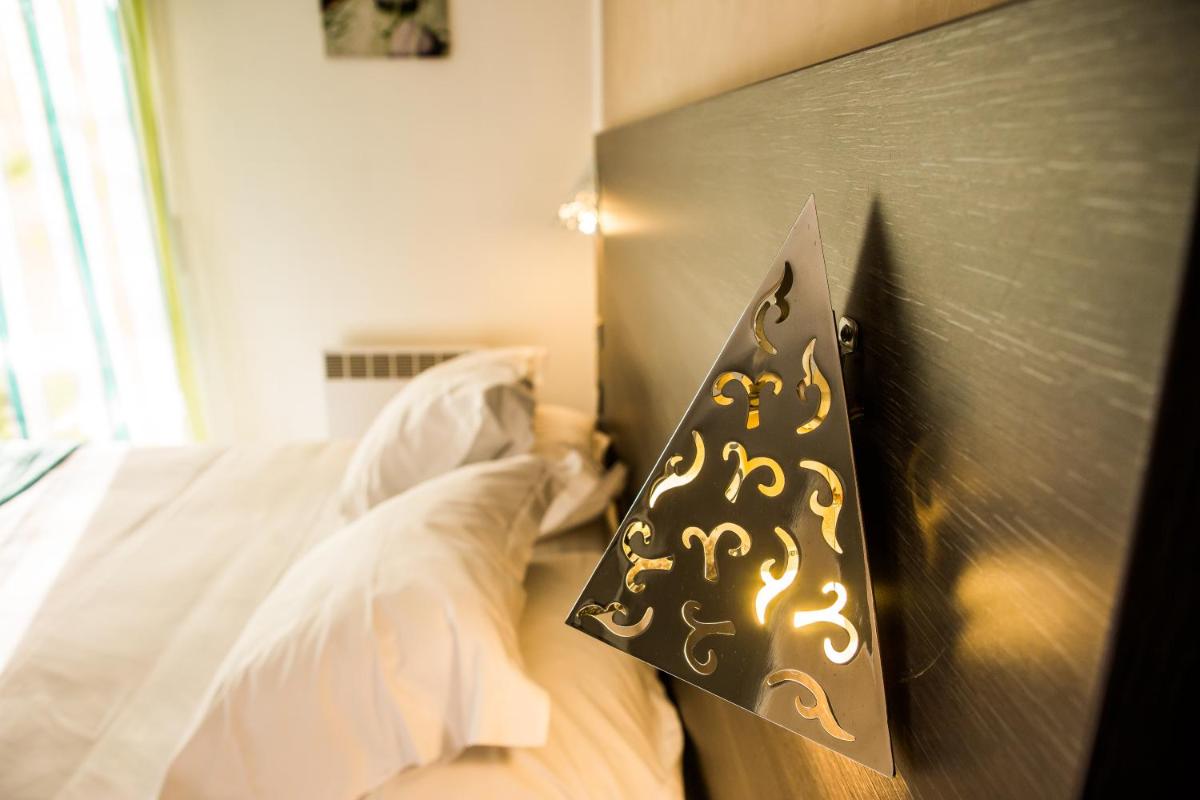 Un ou plusieurs lits dans un hébergement de l'établissement Logis Hotel Restaurant SPA Les Oliviers