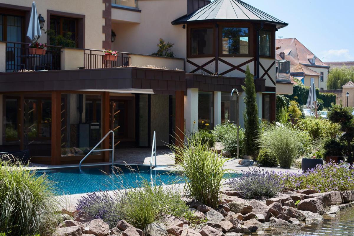 une maison avec une piscine et un kiosque dans l'établissement Hotel Spa Restaurant Domaine du Moulin, à Ensisheim