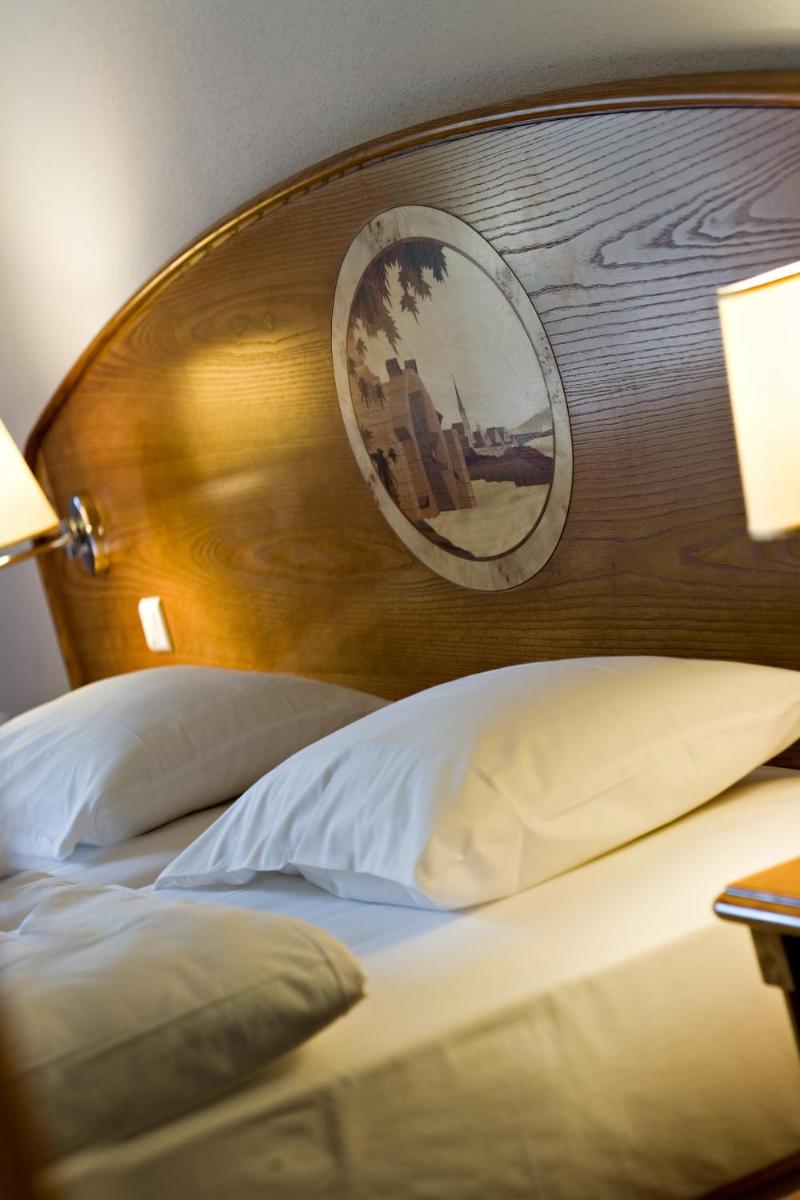 Un ou plusieurs lits dans un hébergement de l'établissement Hotel Spa Restaurant Domaine du Moulin