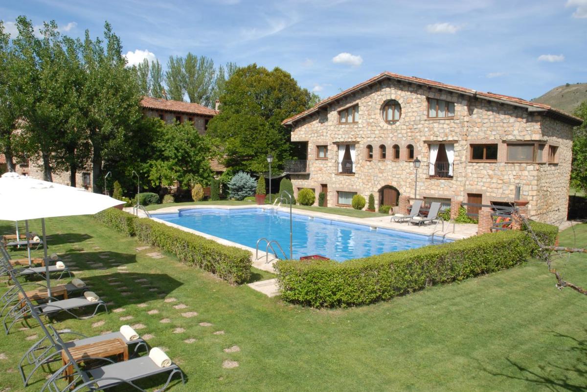 - Vistas al exterior de una casa de piedra con piscina en Molino de Alcuneza Relais & Châteaux, en Sigüenza