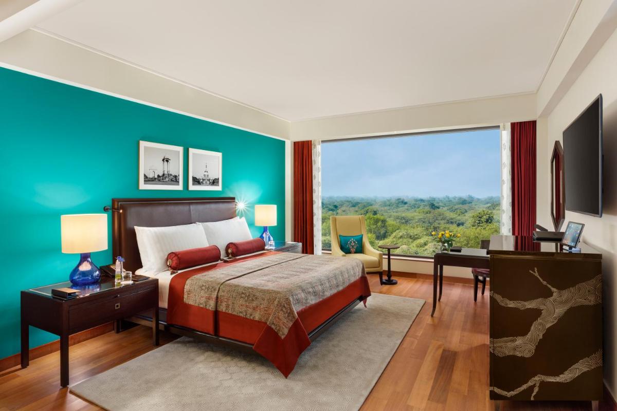 a bedroom with a bed and a large window at The Oberoi New Delhi in New Delhi a bedroom with a bed and a large window at The Oberoi New Delhi in New Delhi