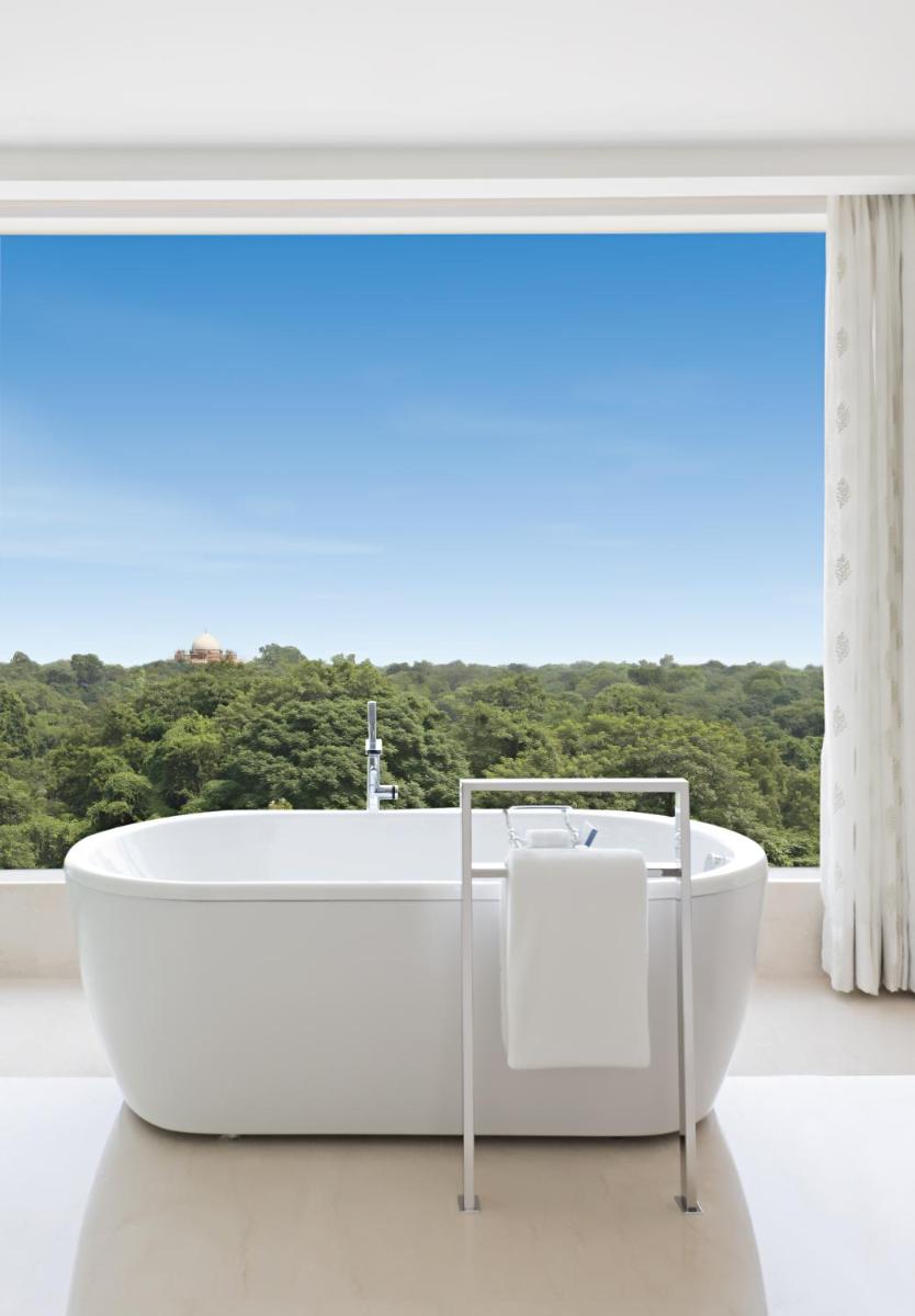 a white bath tub sitting in front of a window at The Oberoi New Delhi in New Delhi a white bath tub sitting in front of a window at The Oberoi New Delhi in New Delhi