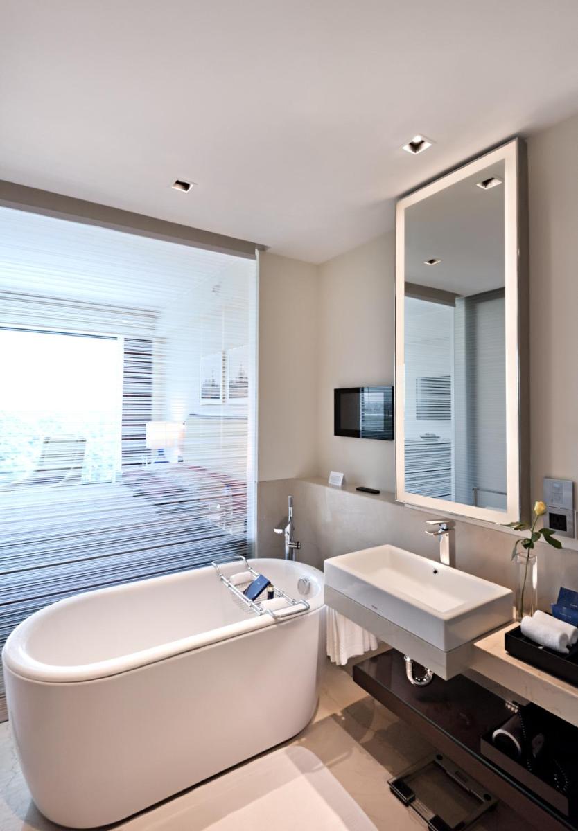a large white bathroom with a tub and a sink at The Oberoi New Delhi in New Delhi a large white bathroom with a tub and a sink at The Oberoi New Delhi in New Delhi