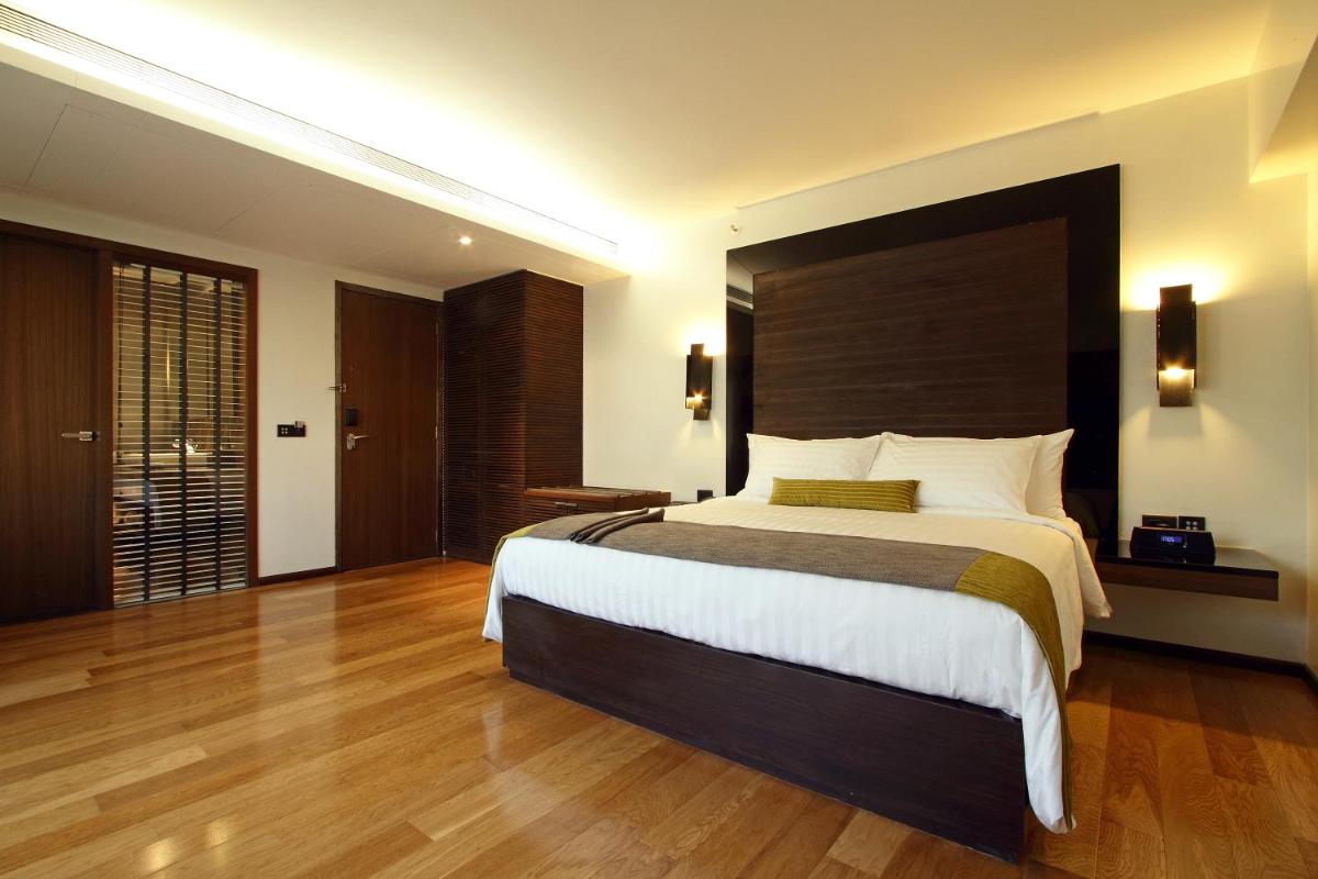 a bedroom with a large bed with a large headboard at Svenska Design Hotel in Mumbai