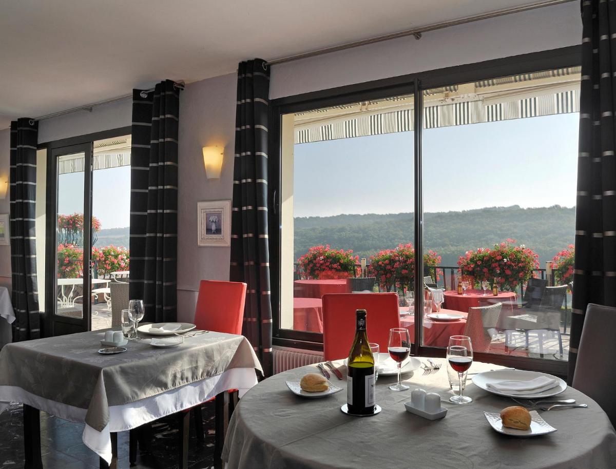 - un restaurant avec deux tables et une bouteille de vin dans l'établissement Auberge Du Camp Romain, à Chassey-le-Camp