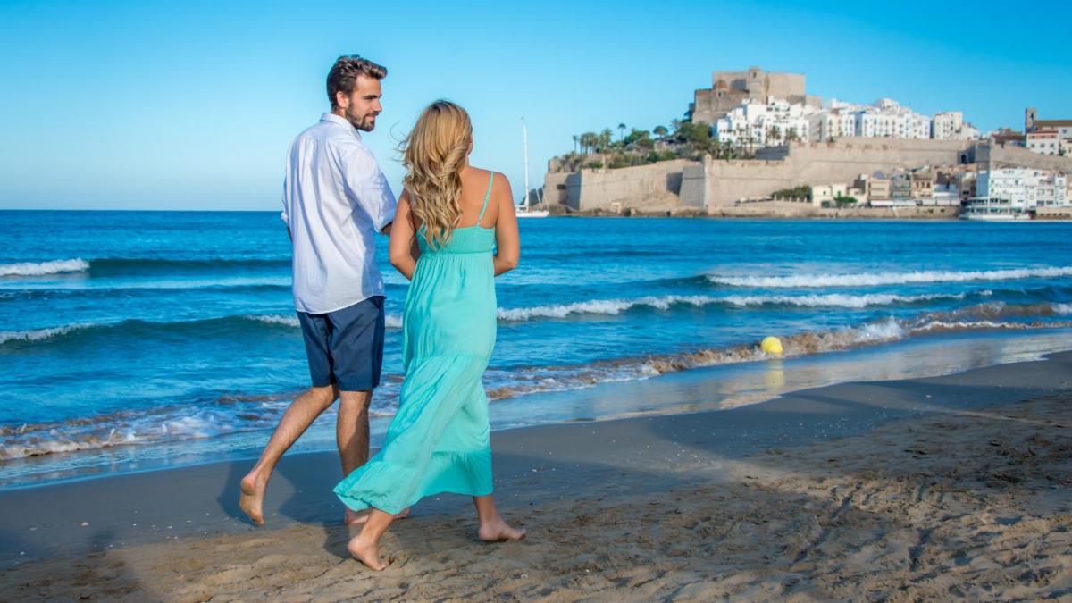 un hombre y una mujer caminando por la playa en Hotel RH Portocristo & Wellness, en Peñíscola 26 fotos más
