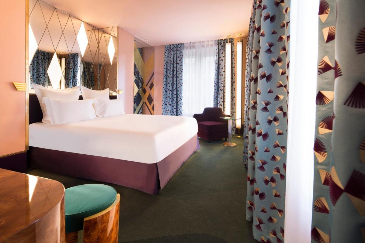 une chambre d'hôtel avec un lit et une chaise dans l'établissement Hôtel Saint-Marc, à Paris 71 autres photos