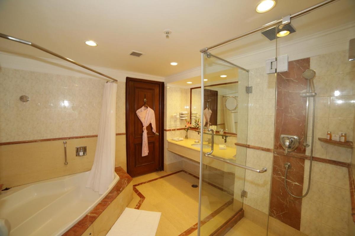 a bathroom with a shower and a tub and a sink at Jaypee Palace Hotel in Agra