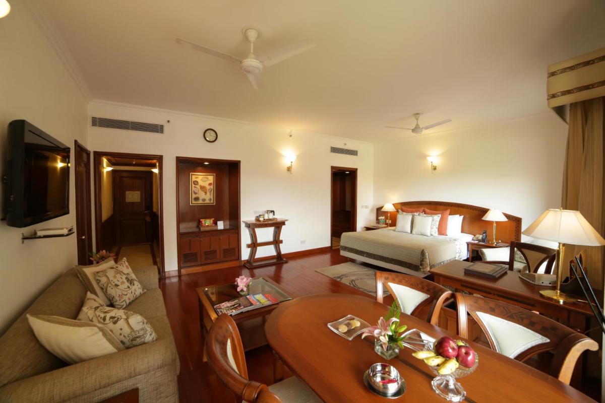 a hotel room with a bed and a living room at Jaypee Palace Hotel in Agra