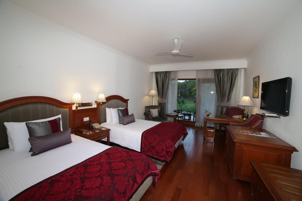 a hotel room with two beds and a flat screen tv at Jaypee Palace Hotel in Agra