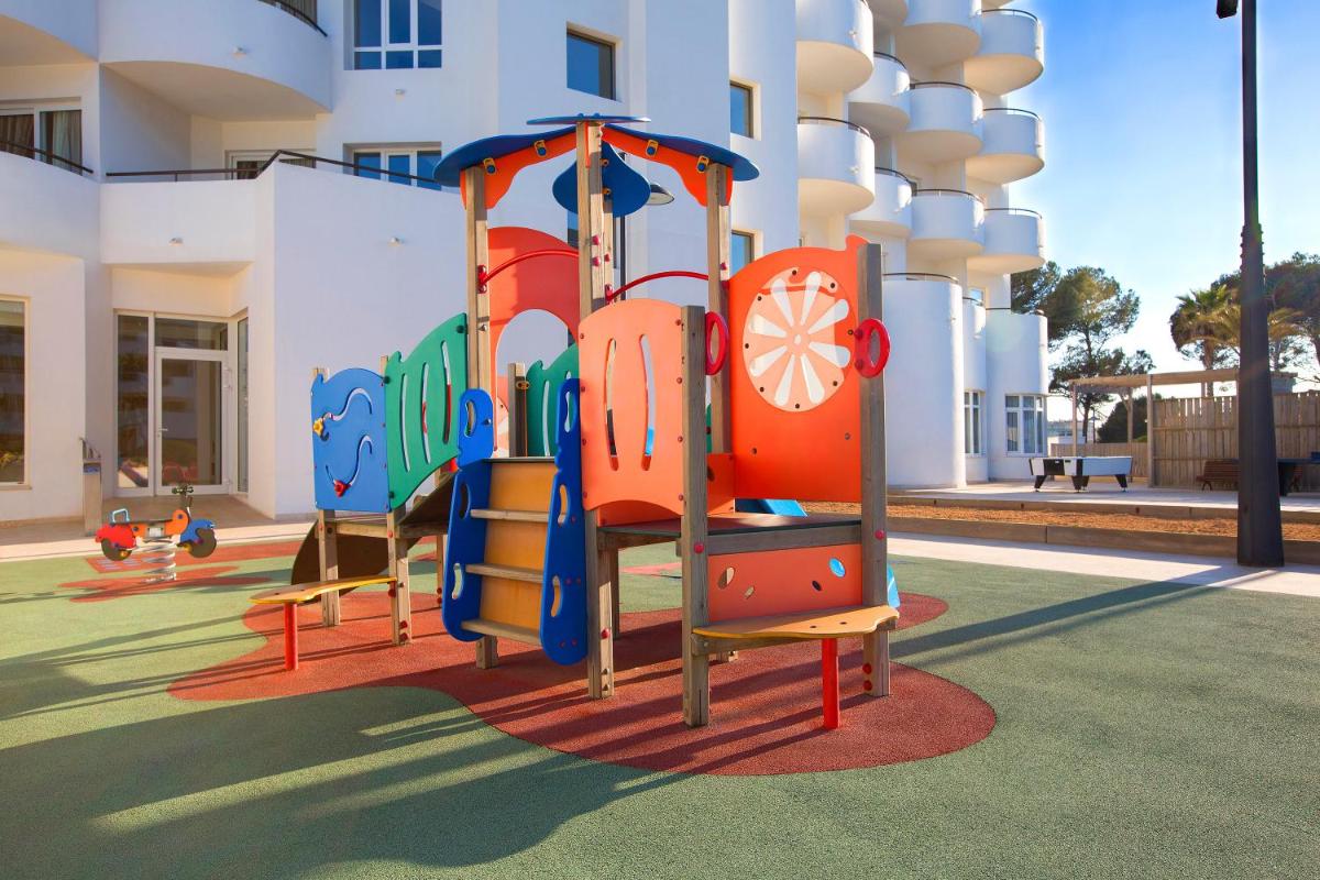 un parque infantil frente a un edificio en Hipotels Hipocampo Playa, en Cala Millor