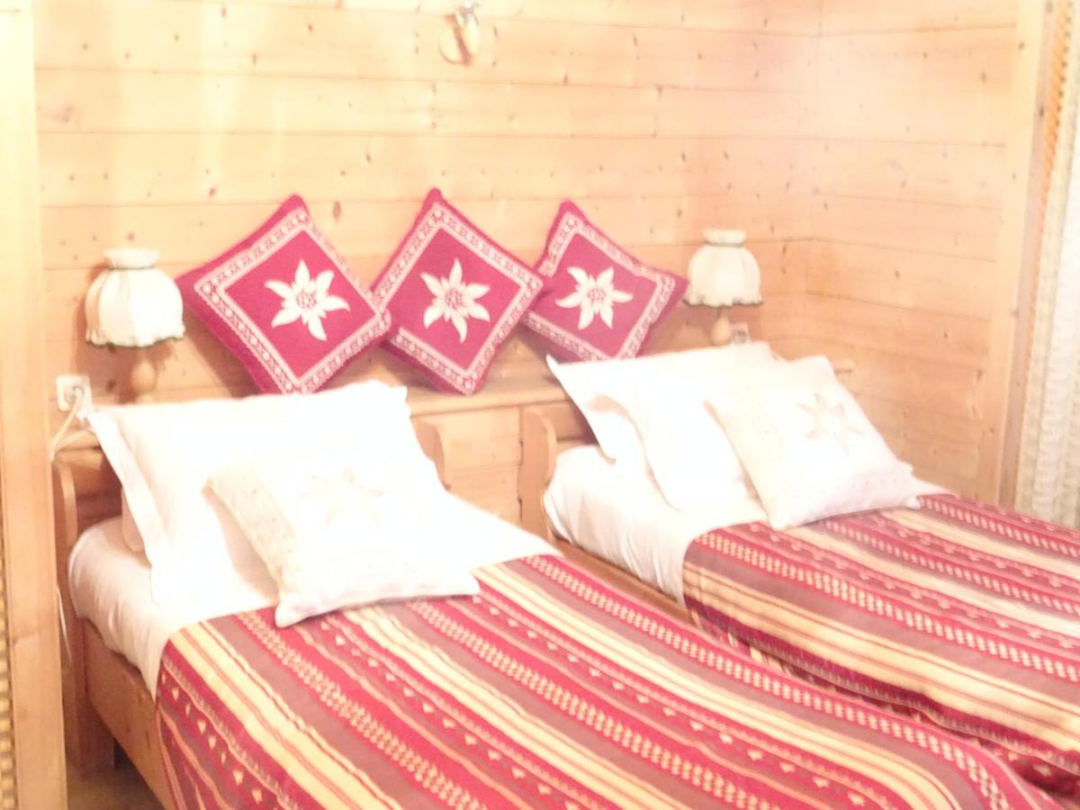 deux lits dans une chambre avec des oreillers rouges et blancs dans l'établissement Apart'hotel & Spa "La Destière", à La Giettaz 90 autres photos