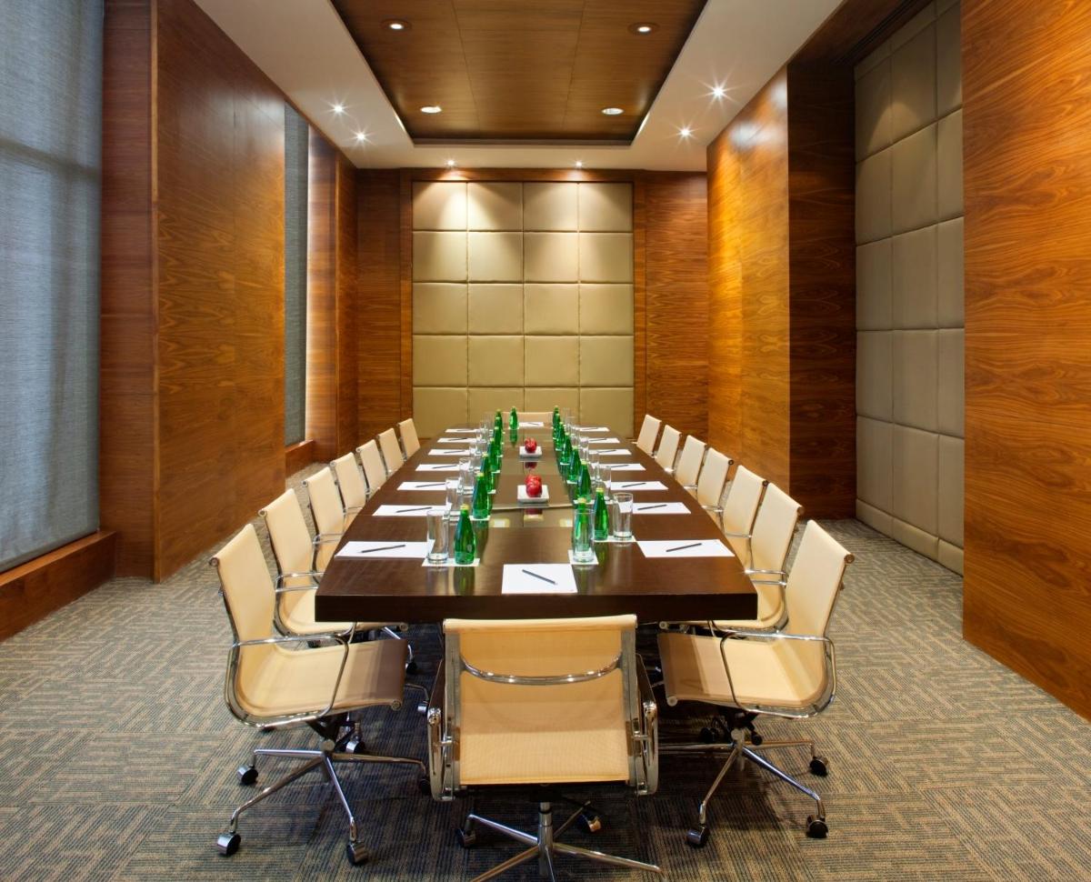 a large conference room with a long table and chairs at Radisson Blu Hotel New Delhi Dwarka in New Delhi a large conference room with a long table and chairs at Radisson Blu Hotel New Delhi Dwarka in New Delhi