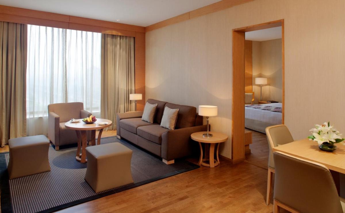 a hotel room with a couch and a bed at Radisson Blu Hotel New Delhi Dwarka in New Delhi a hotel room with a couch and a bed at Radisson Blu Hotel New Delhi Dwarka in New Delhi