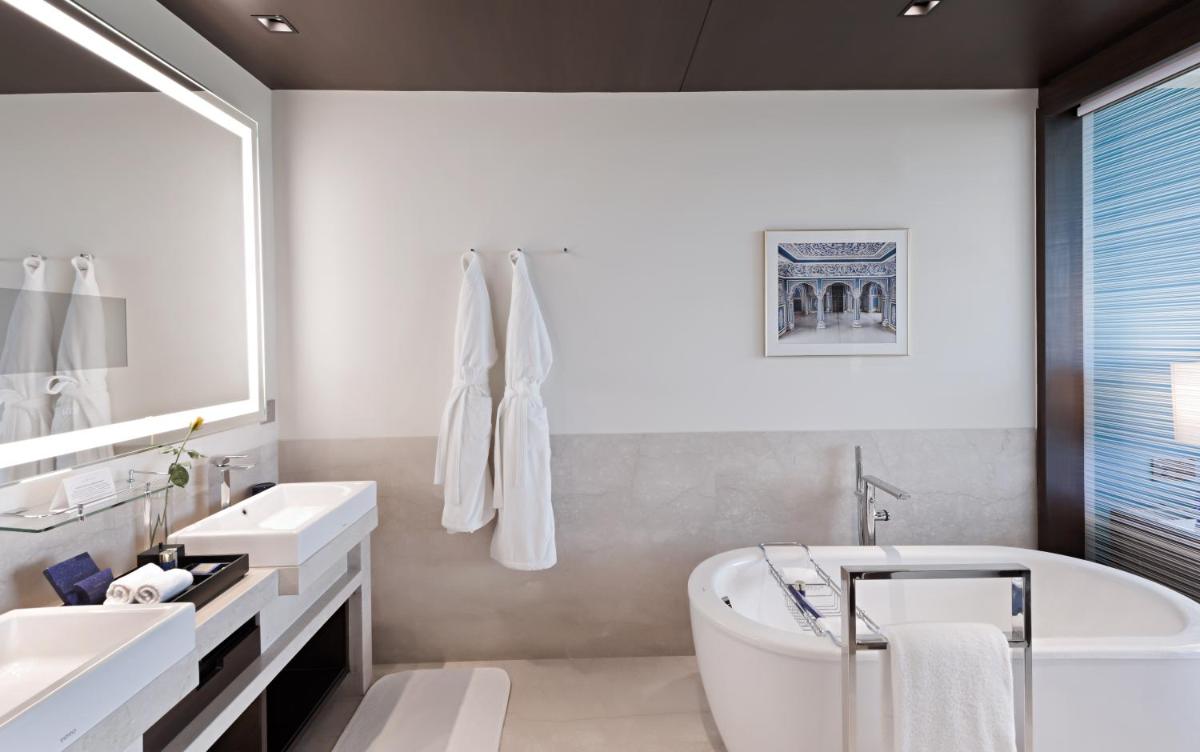 a white bathroom with a tub and a sink at The Oberoi New Delhi in New Delhi a white bathroom with a tub and a sink at The Oberoi New Delhi in New Delhi