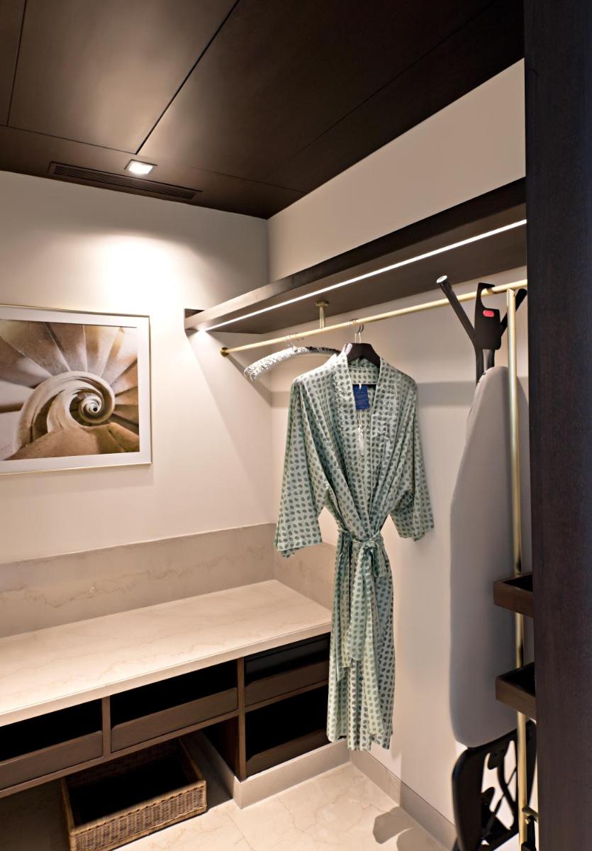 a dressing room with a robe on a rack at The Oberoi New Delhi in New Delhi a dressing room with a robe on a rack at The Oberoi New Delhi in New Delhi