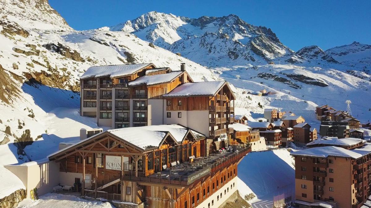 un complexe dans la neige avec des montagnes en arrière-plan dans l'établissement Hôtel Koh-I Nor by Les Etincelles, à Val Thorens