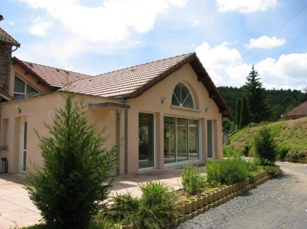 une maison avec une grande fenêtre dans une allée dans l'établissement Hôtel du Bout du Monde, à Saint-Flour