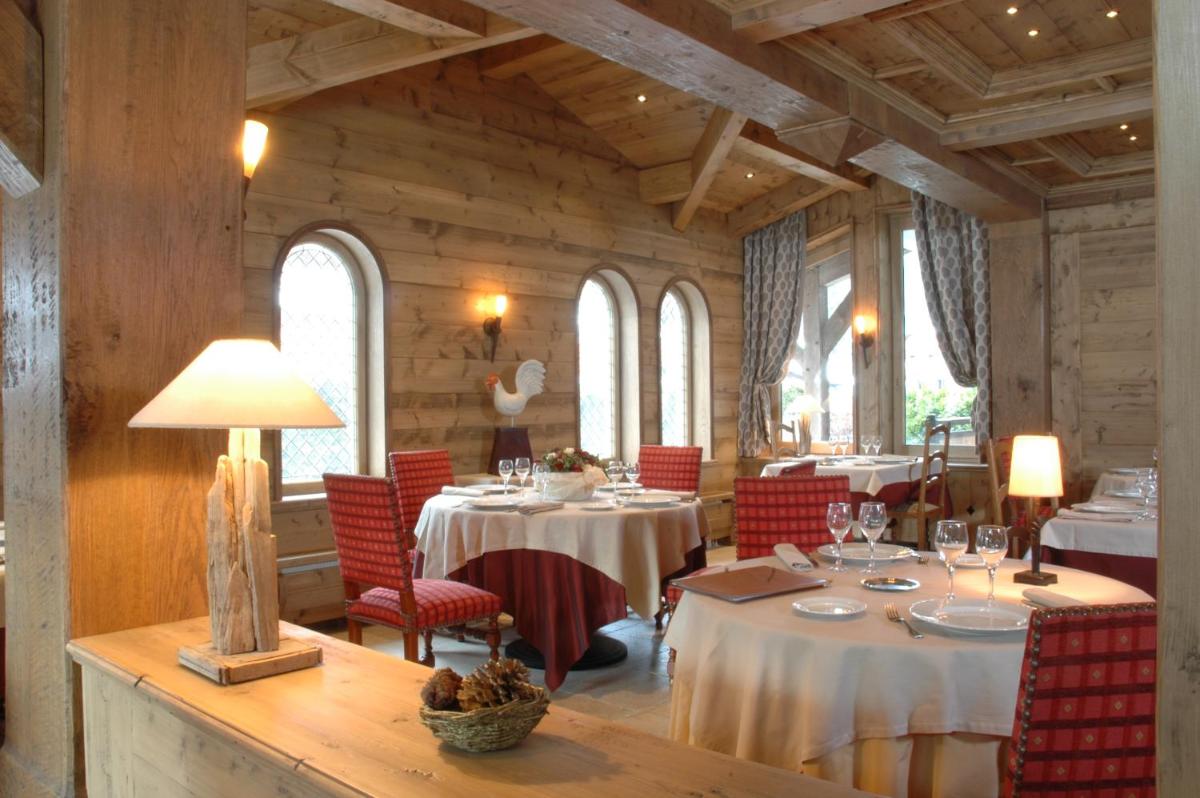 une salle à manger avec des tables et des chaises rouges dans l'établissement Hotel Le Samoyede, à Morzine