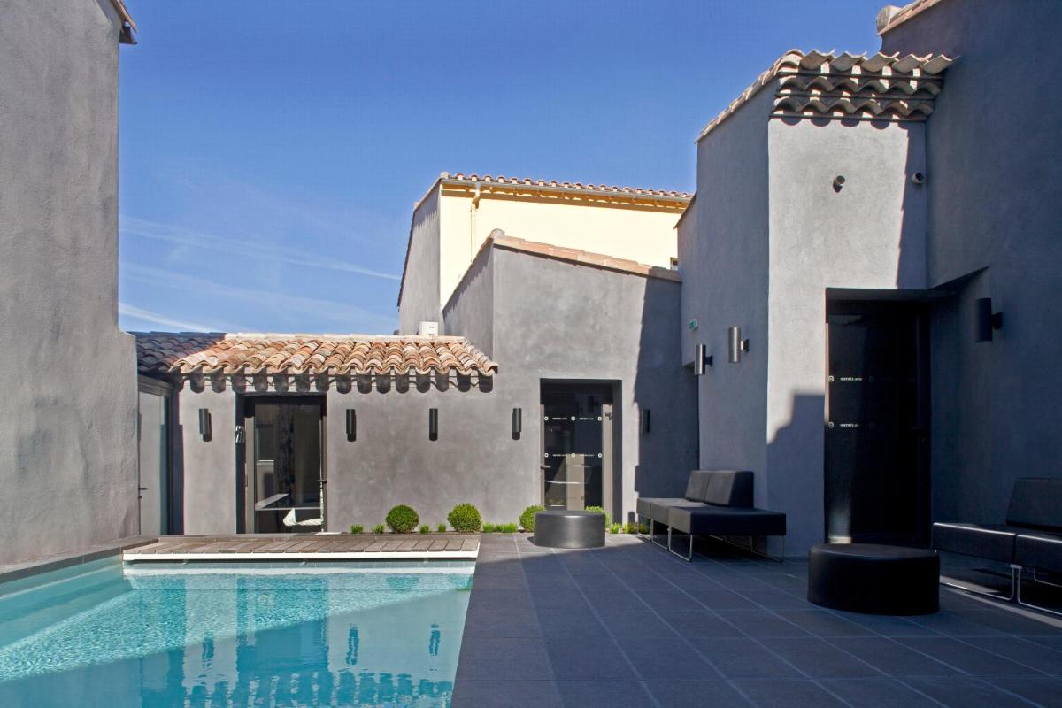 une maison avec une piscine à côté d'un bâtiment dans l'établissement Hôtel De L'octroi, à Carcassonne
