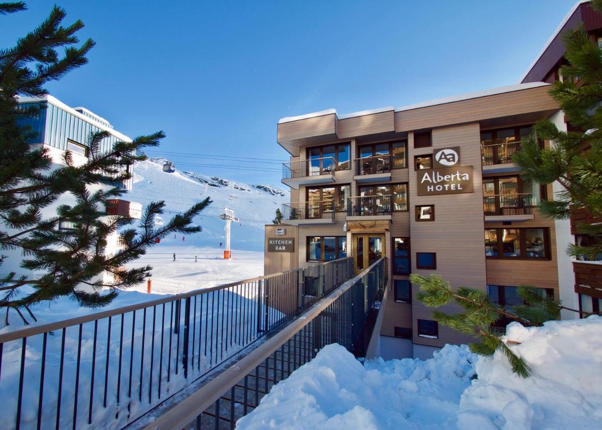 un hôtel dans la neige avec une montagne en arrière-plan dans l'établissement Alberta Hotel & Spa, à Val Thorens