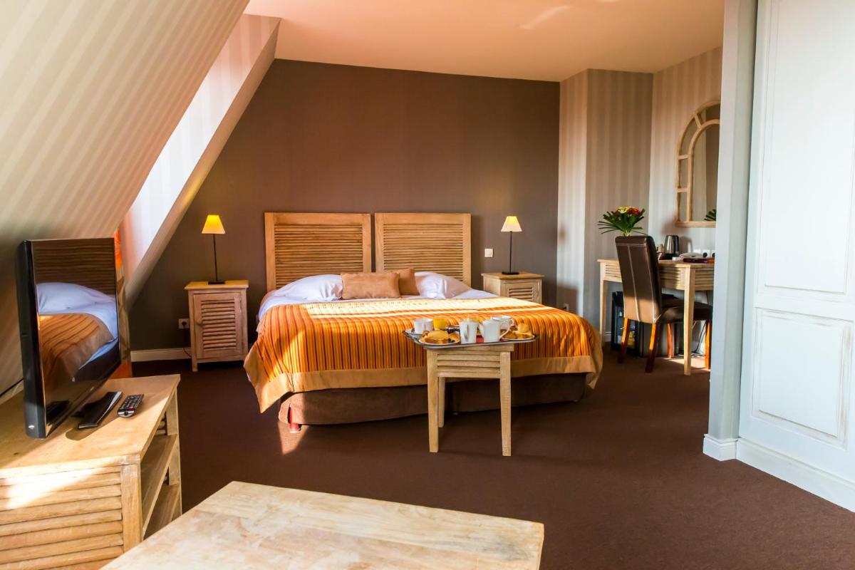 une chambre d'hôtel avec un lit et une table dans l'établissement Almoria Hôtel & SPA, à Deauville