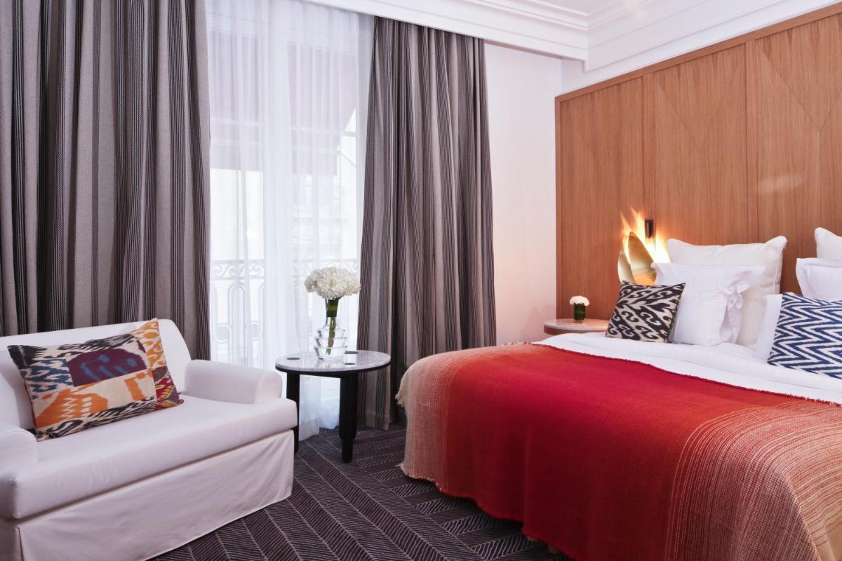 une chambre d'hôtel avec un lit et une chaise dans l'établissement Hôtel Vernet Champs Elysées Paris, à Paris une chambre d'hôtel avec un lit et une chaise dans l'établissement Hôtel Vernet Champs Elysées Paris, à Paris
