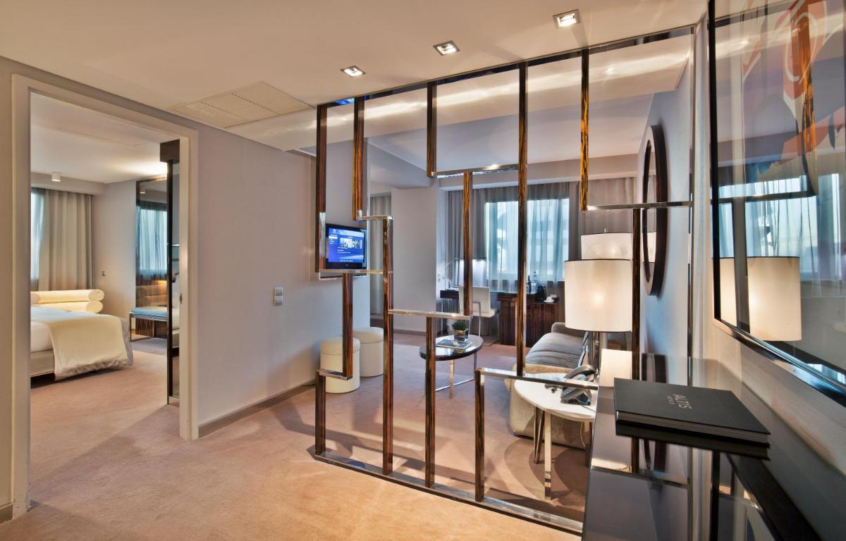 um quarto de hotel com uma cama e uma sala de estar em Altis Grand Hotel em Lisboa