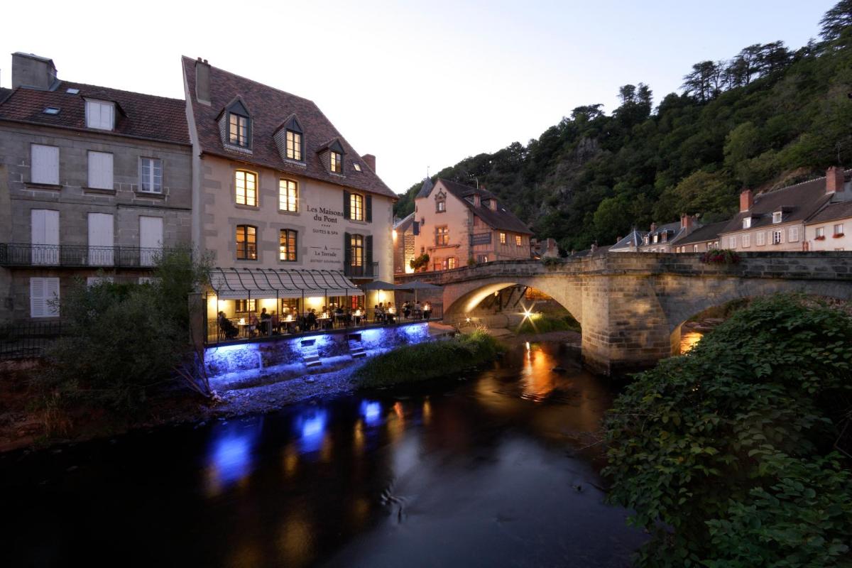 un pont sur une rivière dans une ville avec des bâtiments dans l'établissement Les Maisons du Pont - Charme & Caractère, à Aubusson
