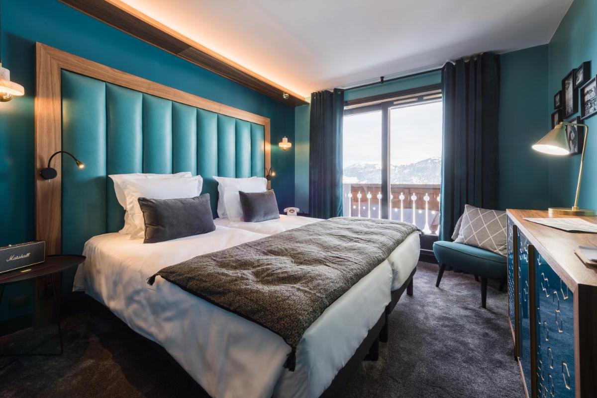 une chambre d'hôtel avec un grand lit et une fenêtre dans l'établissement Fahrenheit Seven Courchevel, à Courchevel
