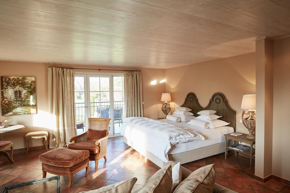 ein Schlafzimmer mit großem Bett und Couch in der Unterkunft Hotel VILLINO in Lindau
