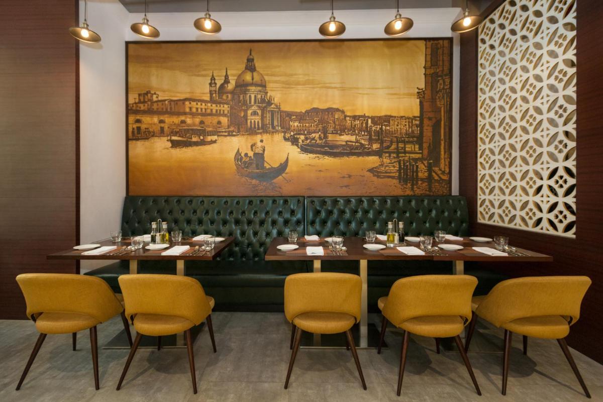 a dining room with a large painting on the wall at The Accord Metropolitan in Chennai