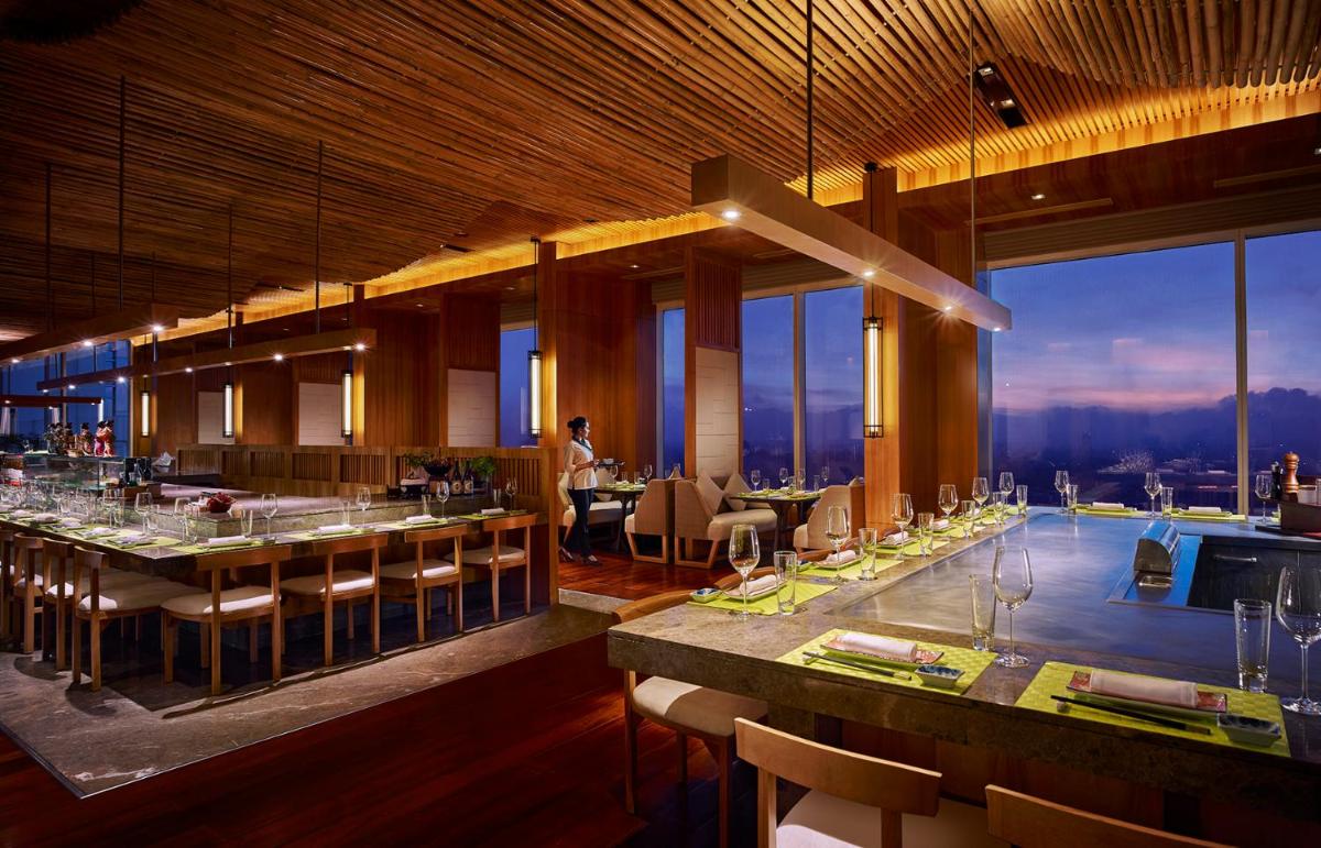 a restaurant with a bar with a view at Shangri-La Bengaluru in Bengaluru a restaurant with a bar with a view at Shangri-La Bengaluru in Bengaluru