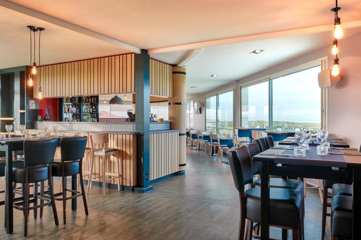 un restaurant avec des tables et des chaises et un bar dans l'établissement Atlanthal, à Anglet