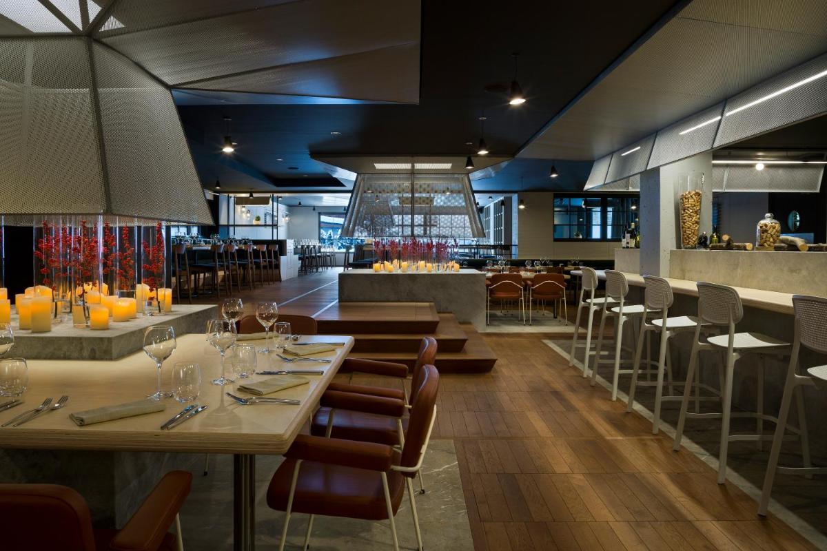 un restaurant avec des tables et des chaises et un bar dans l'établissement Heliopic Hotel & Spa, à Chamonix-Mont-Blanc