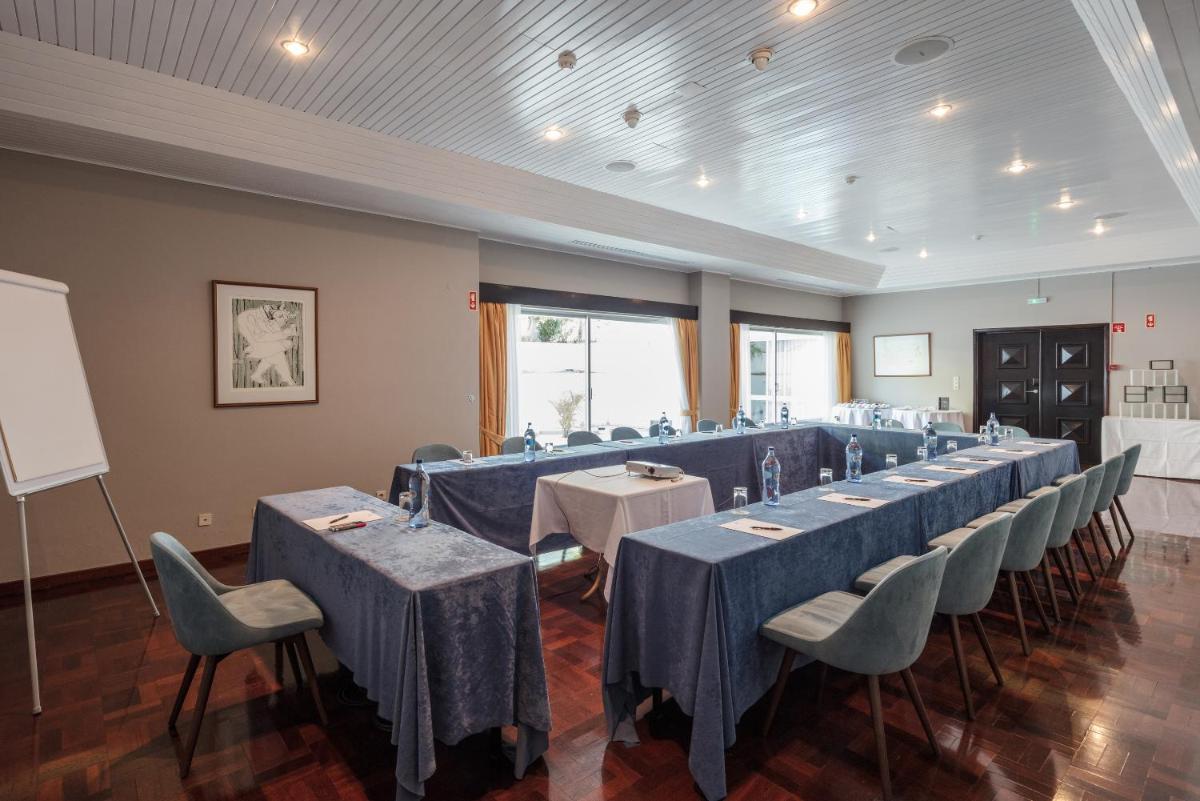 um quarto com uma fila de mesas e cadeiras em Dona Filipa Hotel no Vale do Lobo mais 46 fotografias