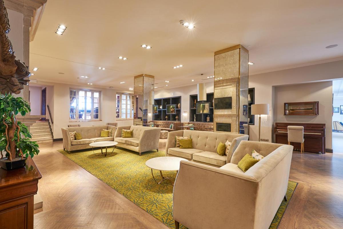 uma grande sala de estar com sofás e uma mesa em Dona Filipa Hotel no Vale do Lobo