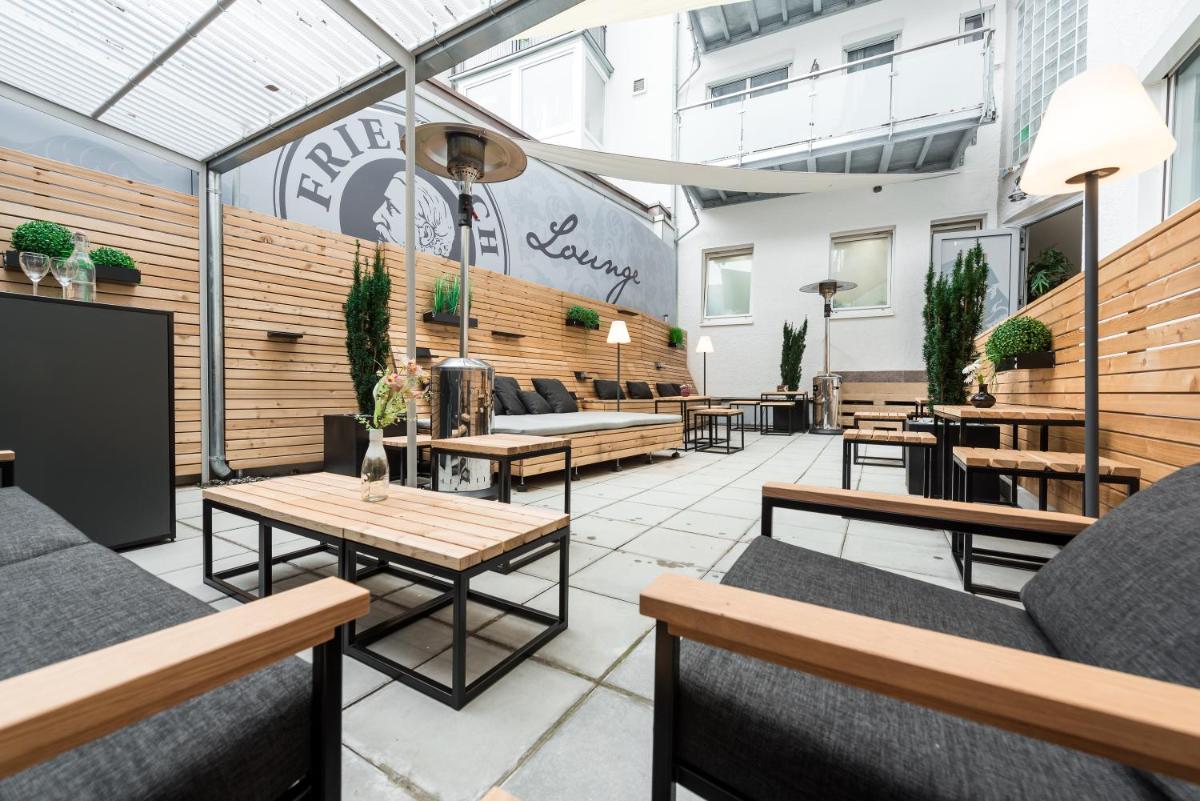 ein Restaurant mit Sofas und Tischen in einem Gebäude in der Unterkunft Friedrich Boutique-Apartments in Freiburg im Breisgau