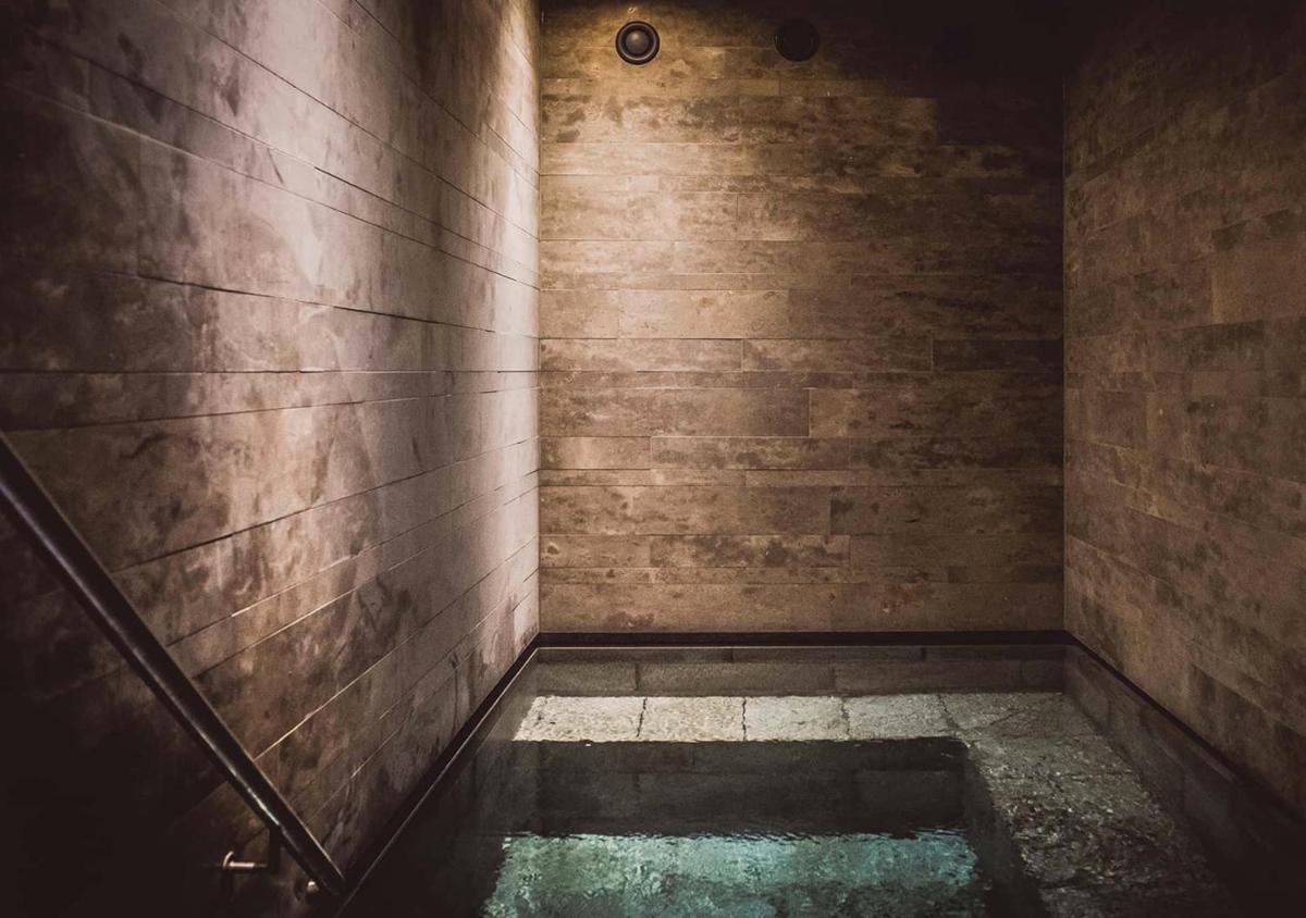 ein dunkler Raum mit einem Wasserbecken in der Unterkunft Spa & Resort Bachmair Weissach, LUXURY FAMILY RESORT in Rottach-Egern