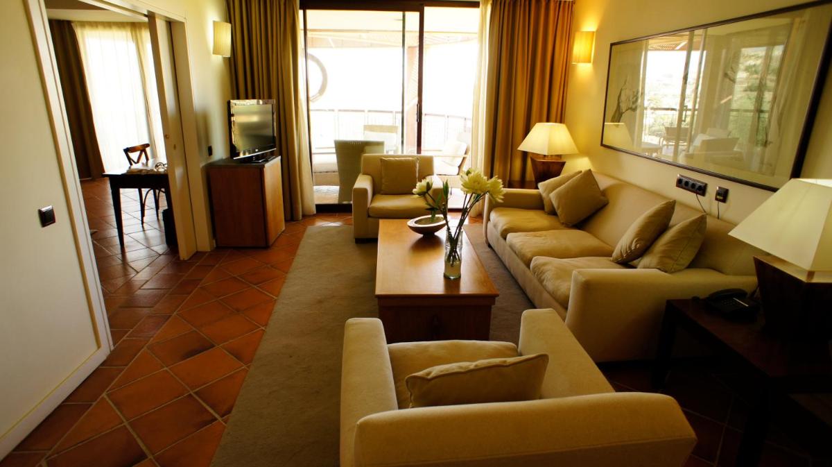 Una sala de estar con sofás y una mesa de café. en Hotel Cigarral el Bosque, en Toledo