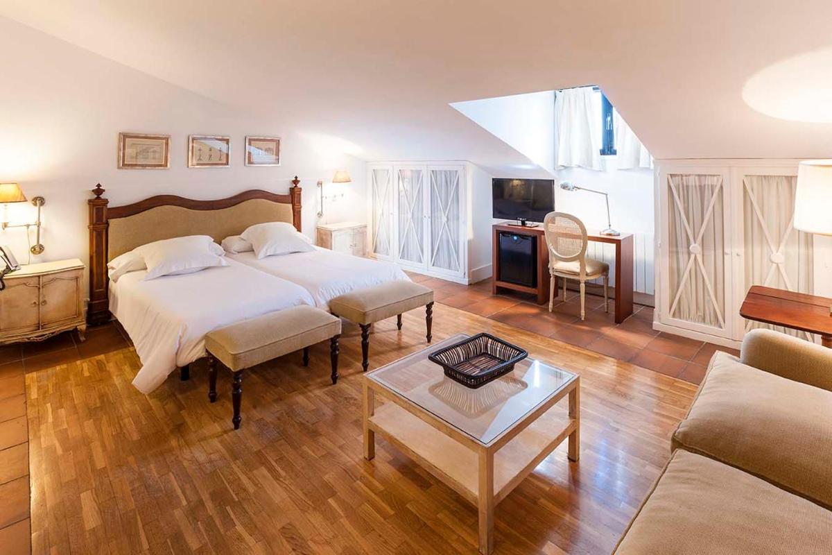 Un dormitorio con una cama y una sala de estar. en Hotel Spa Salinas de Imón, en Imón