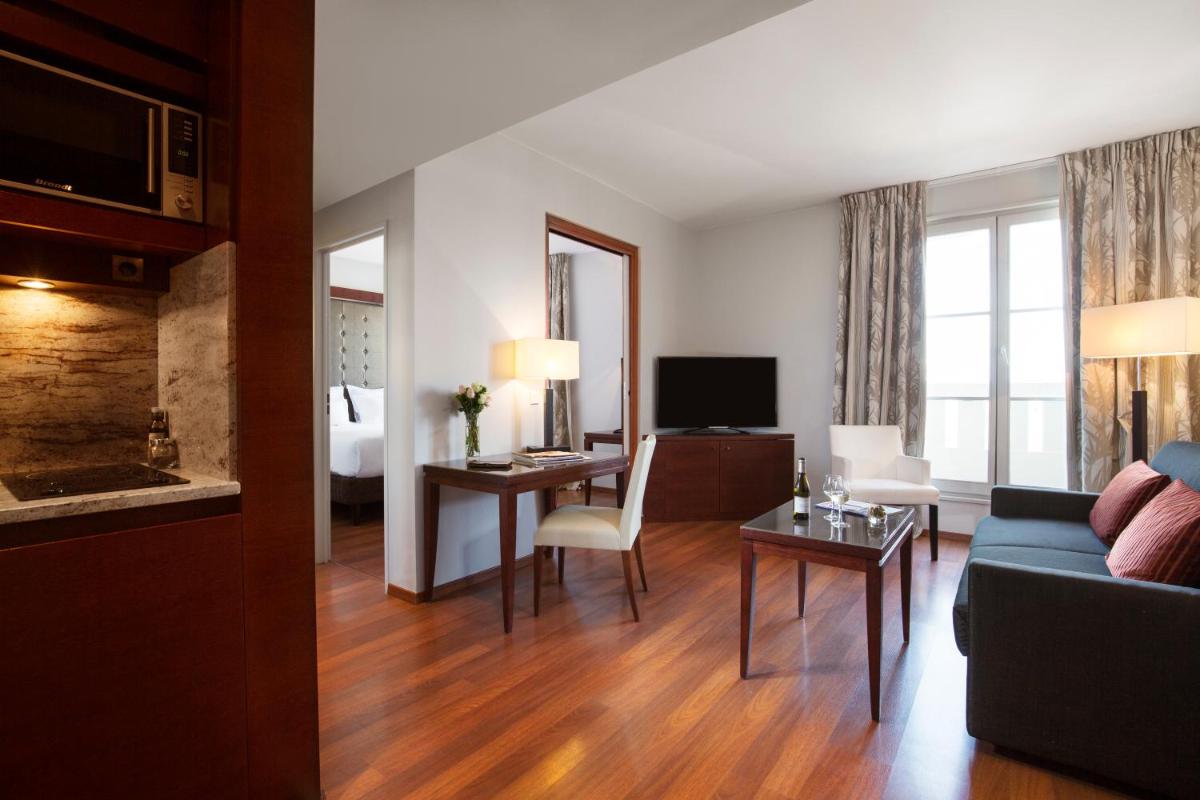 un salon avec un canapé et une chambre avec une télévision dans l'établissement Relais Spa Val d'Europe, à Chessy