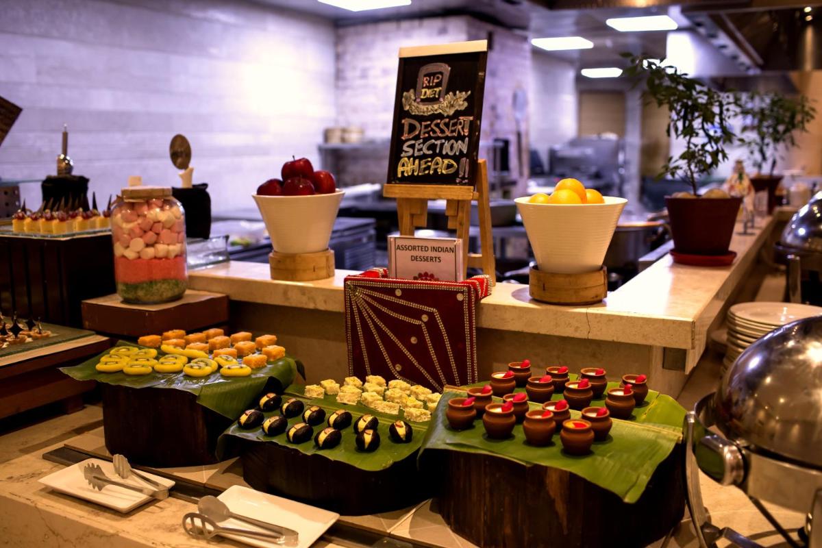 a display of different types of food on a counter at The Lalit Chandigarh in Chandīgarh