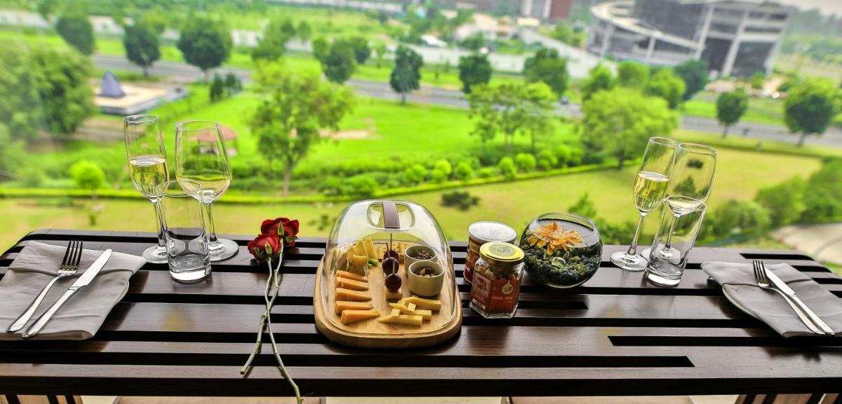 a table with a tray of food and wine glasses at The Lalit Chandigarh in Chandīgarh