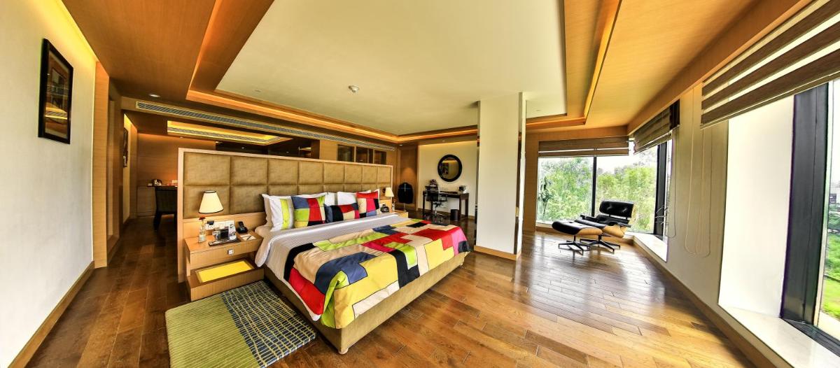 a bedroom with a bed and a large window at The Lalit Chandigarh in Chandīgarh