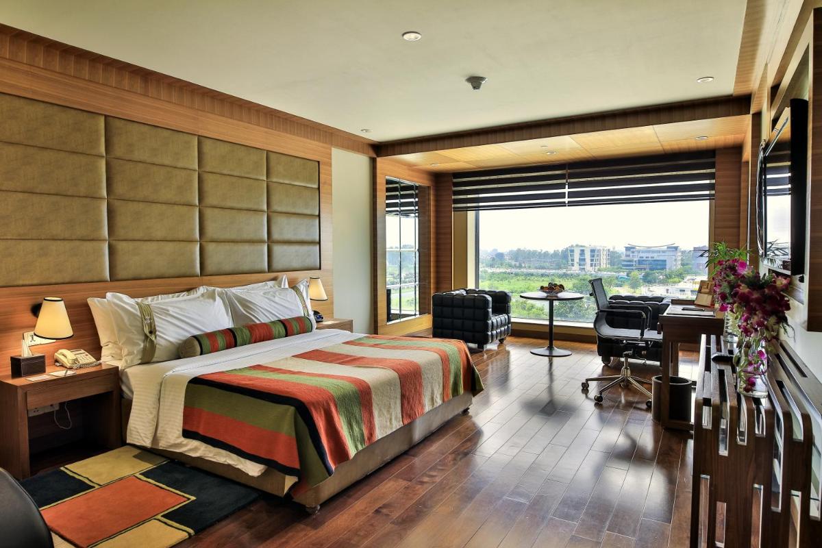 a hotel room with a bed and a desk and a window at The Lalit Chandigarh in Chandīgarh